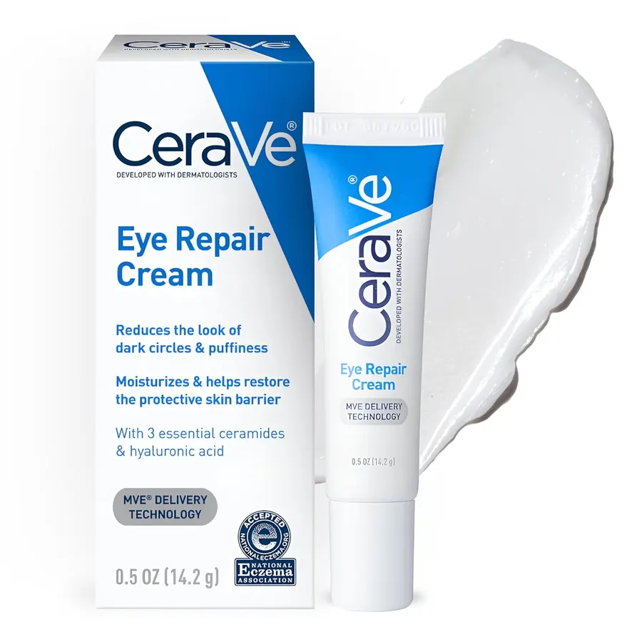 Close-up of a small jar of CeraVe Eye Repair Cream held between two fingers against a blush-toned background