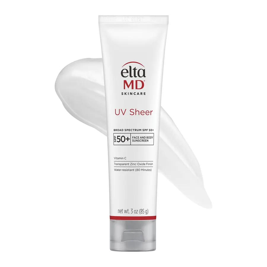 Close-up of EltaMD UV Sheer sunscreen tube held in a hand outdoors in sunlight
