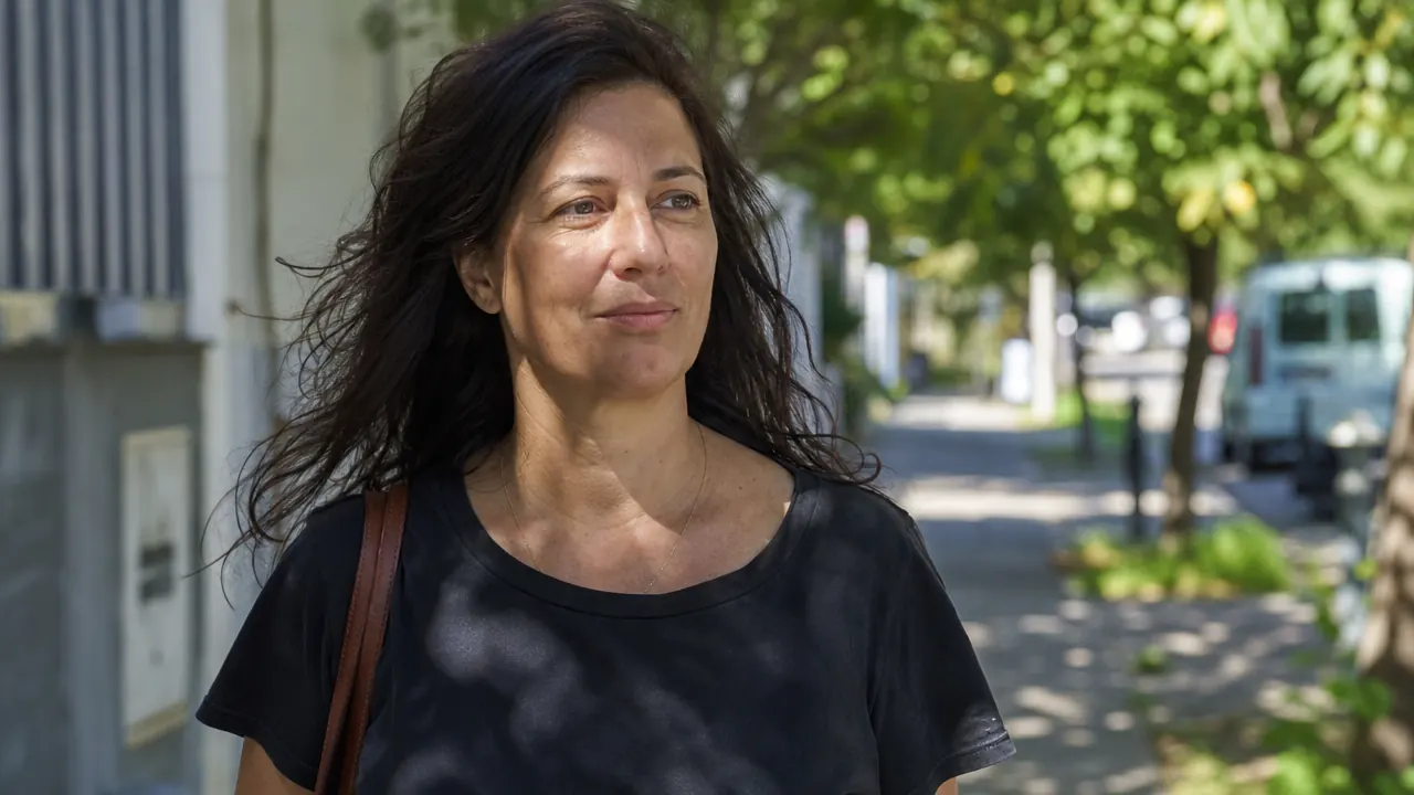 Woman smiling on a sunny outdoor walk, relaxed and comfortable in natural daylight